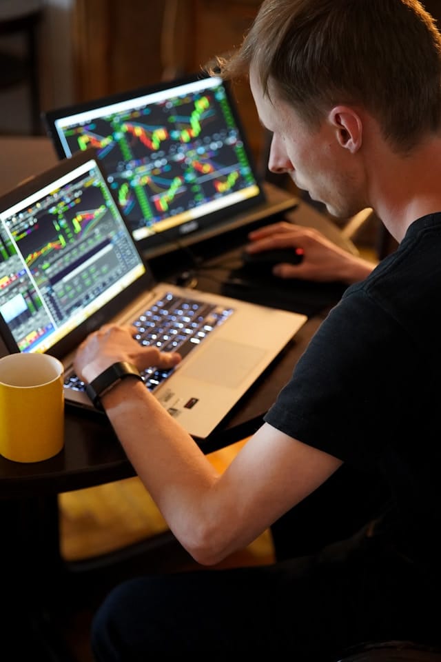 Trader working with automated strategies on a laptop